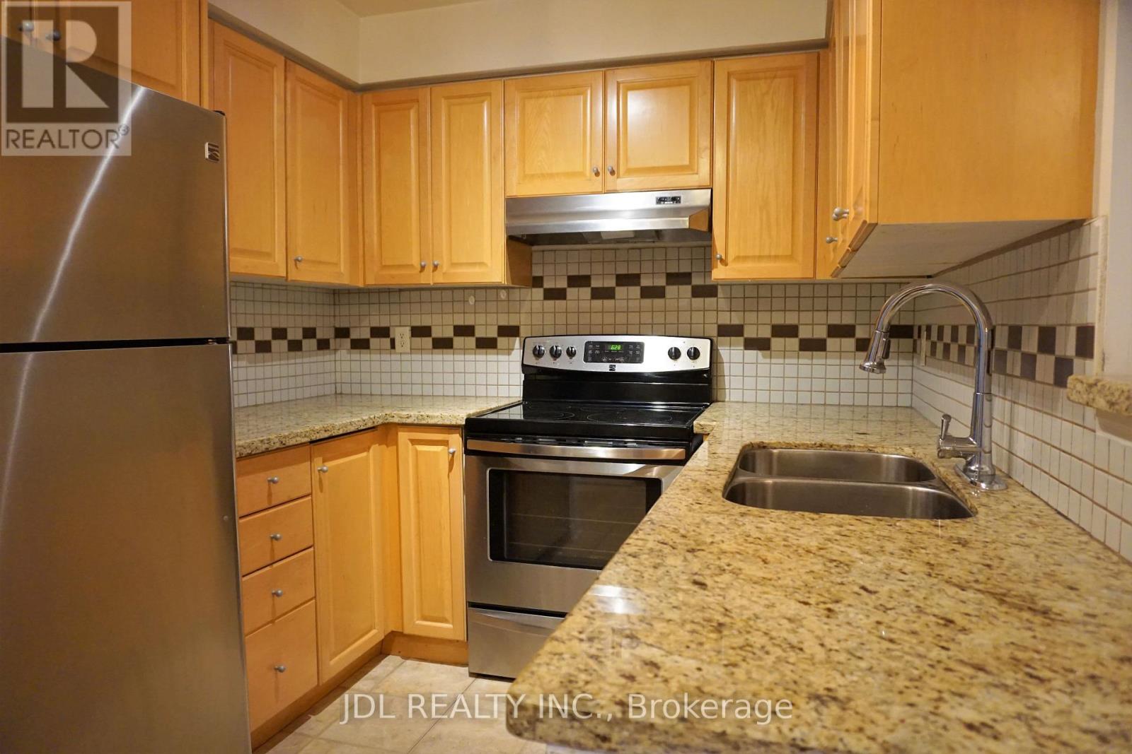 A kitchen with wooden cabinets and a granite countertop.