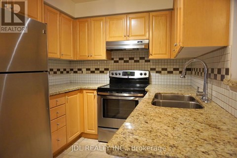 A kitchen with wooden cabinets and a granite countertop.