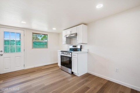 A kitchen with a white oven and cabinets.