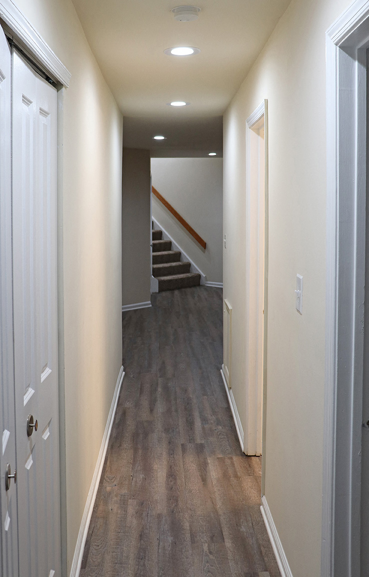 a look down the hallway of a new home with stairs