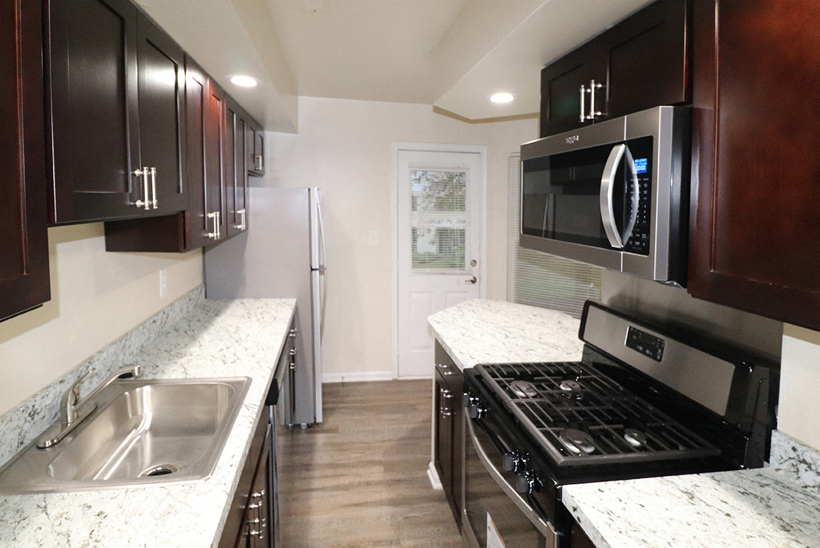 a kitchen with granite counter tops and a stainless steel stove