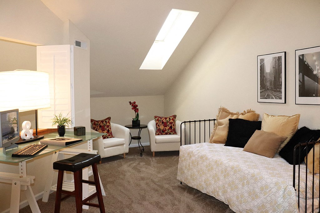 a bedroom with a bed and a desk in a room