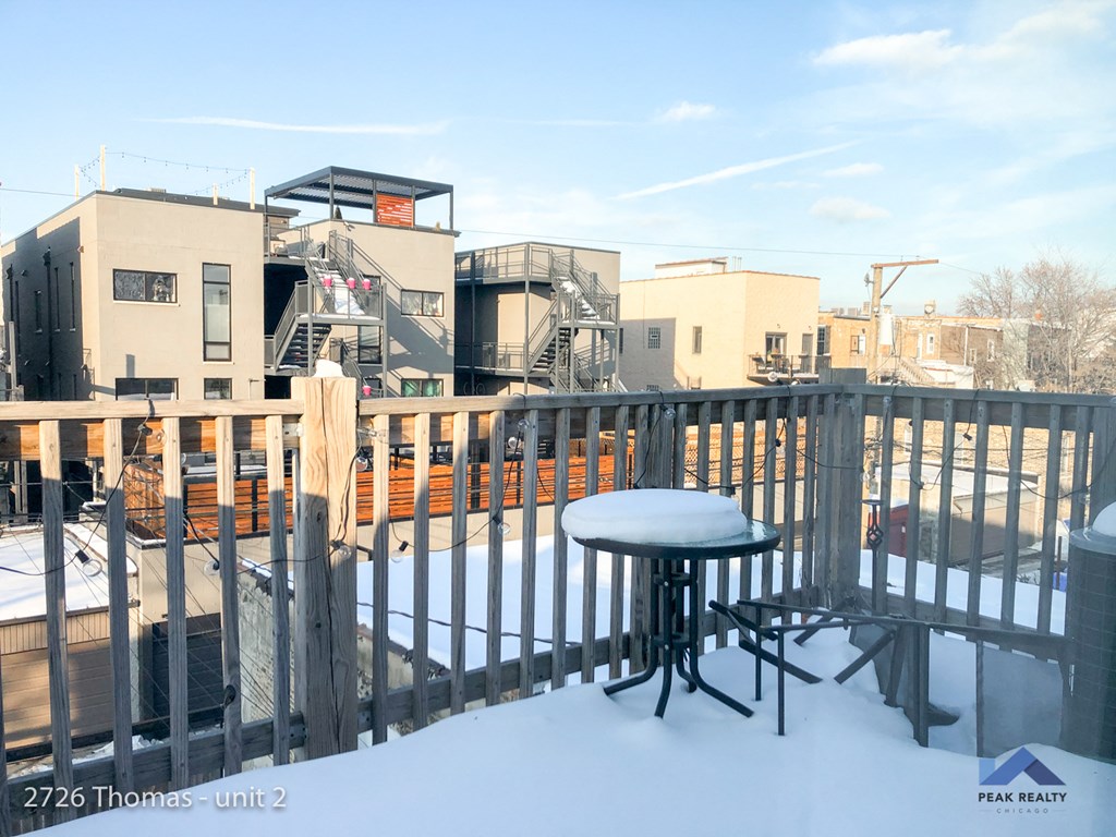 a deck with a table and chairs covered in snow