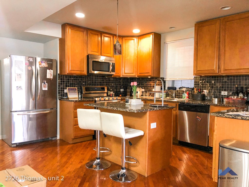 a kitchen with stainless steel appliances and wooden cabinets