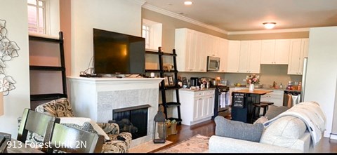 a living room with a fireplace and a kitchen
