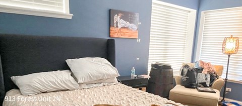 a bedroom with blue walls and a bed with pillows