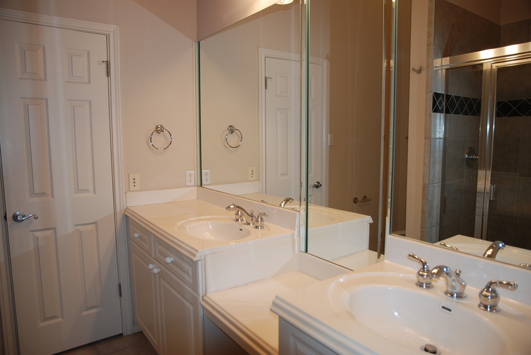 A bathroom with a white sink and a mirror.