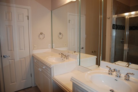 A bathroom with a white sink and a mirror.