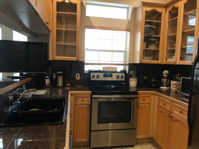 A kitchen with wooden cabinets and black appliances.