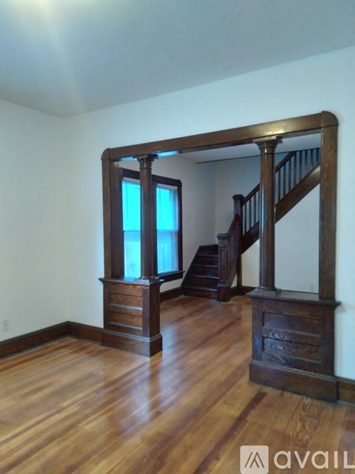 A wooden staircase with a railing and a window.