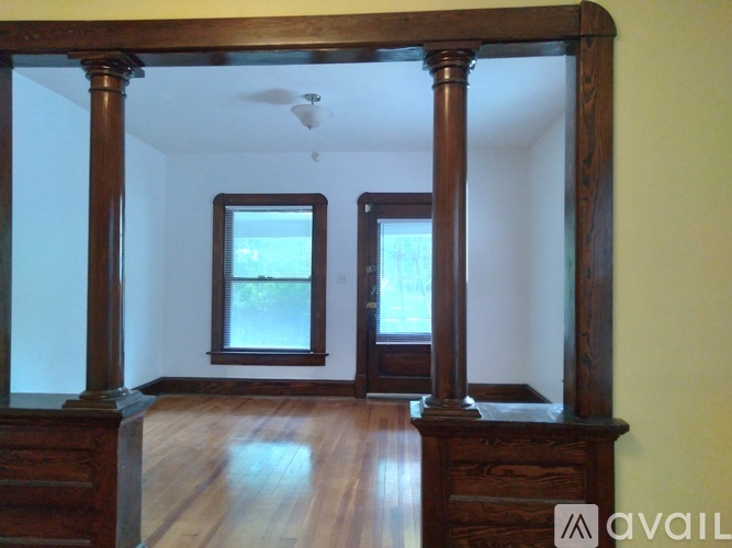 A room with wooden floors and a large mirror on the wall.