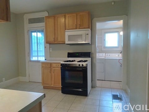 A kitchen with a white counter top and wooden cabinets.