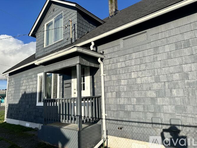 A house with a grey exterior and a balcony.