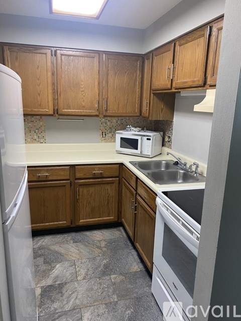 A kitchen with wooden cabinets and a white microwave.