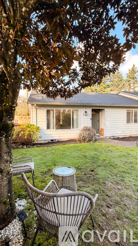 A house with a lawn and a tree in front of it.