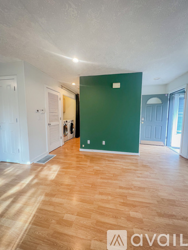 A room with wooden flooring and a green wall.