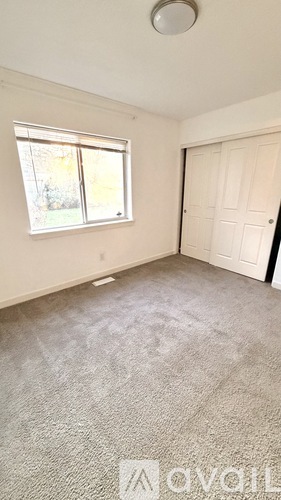 A bedroom with a bed, nightstand, and two pictures on the wall.