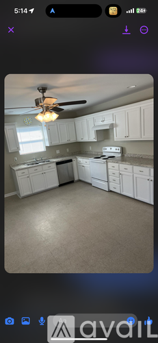 A kitchen with white cabinets and a ceiling fan.