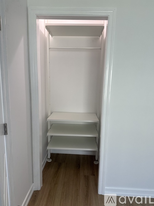 A white closet with shelves and a door.