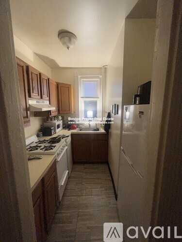 A kitchen with wooden cabinets and a white fridge.