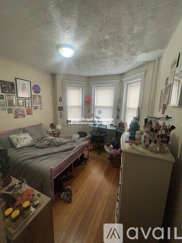 A bedroom with a bed, desk, and chair.