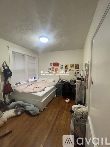 A bedroom with a bed, a desk, and a chair.