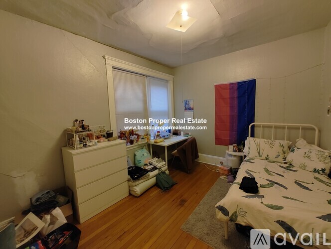 A bedroom with a bed, dresser, and window.