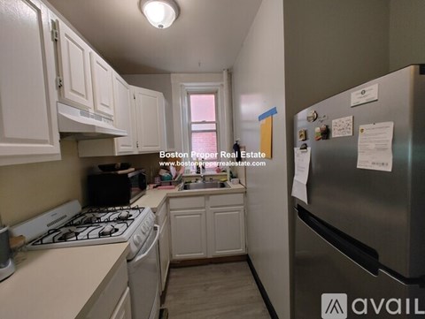 A kitchen with a refrigerator, stove, and dishwasher.