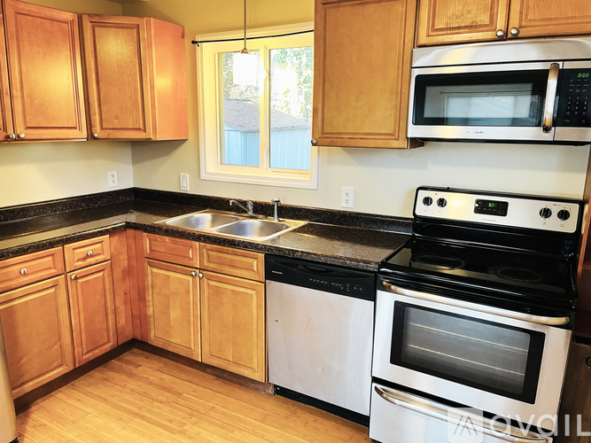A kitchen with wooden cabinets and a black countertop.