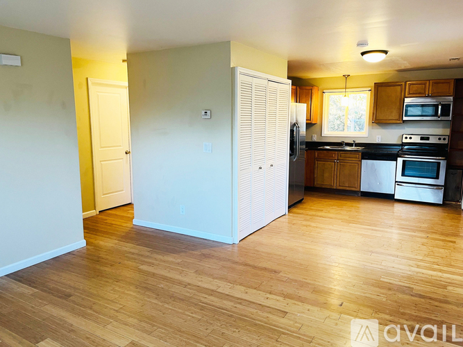 A kitchen with wooden floors and white appliances.