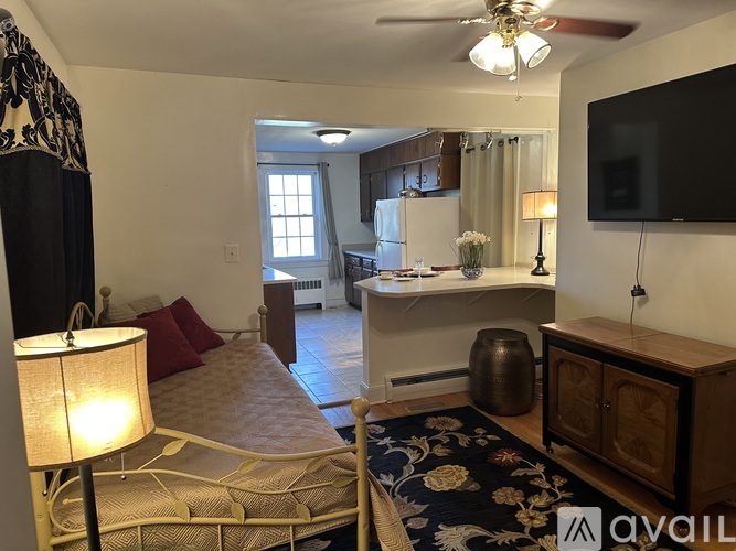A bedroom with a bed, a desk, and a television.