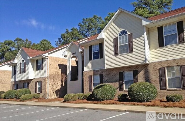 A row of houses with a parking lot in front.