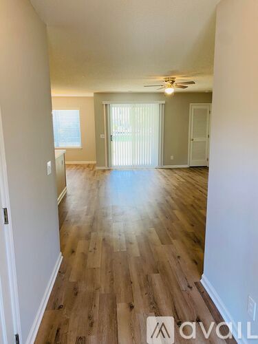 A room with wooden flooring and a ceiling fan.