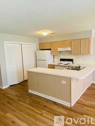 A kitchen with wooden floors and white walls.