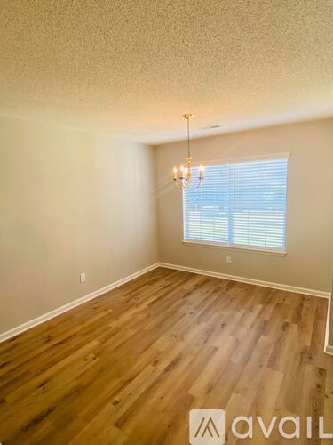 A room with wooden flooring and a chandelier.