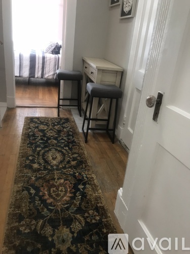 A hallway with a rug and a desk.