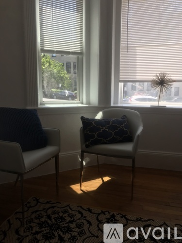 A chair with a blue pillow is in front of a window.
