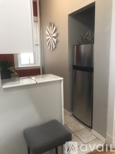 A kitchen with a stainless steel refrigerator and a white countertop.