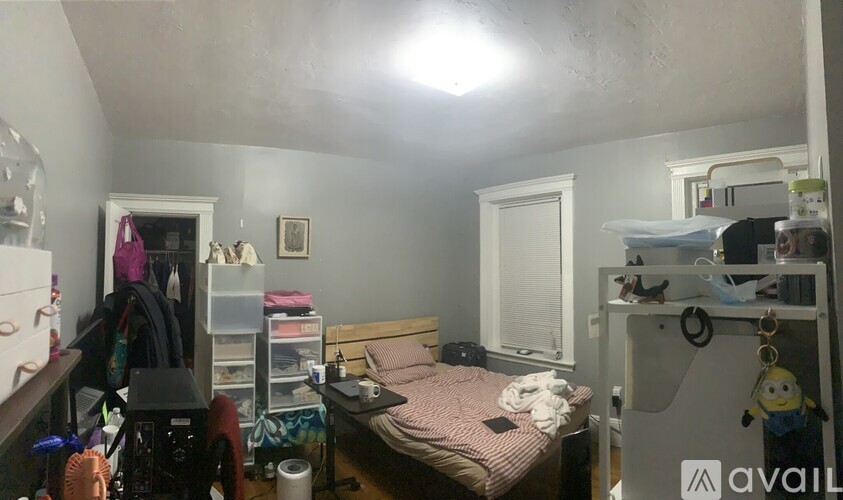A bedroom with a bed, a desk, and a closet.