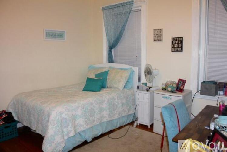 A bedroom with a bed, desk, and chair.