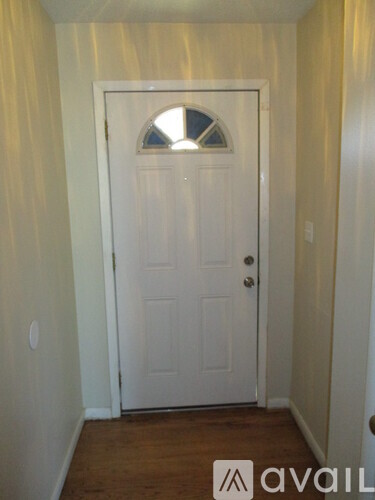 A white door with a window in the middle of it.