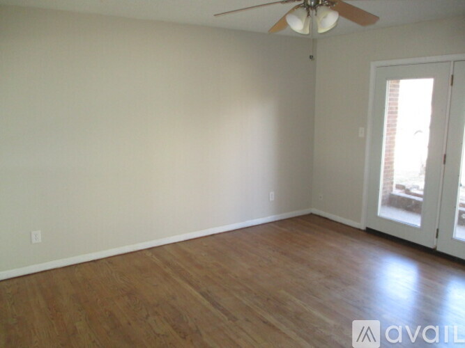 A room with a ceiling fan and wooden flooring.