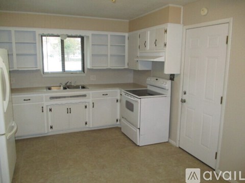 A kitchen with white appliances and cabinets.