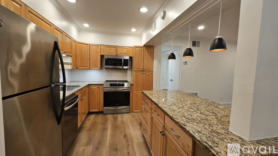 A kitchen with wooden cabinets and granite countertops.