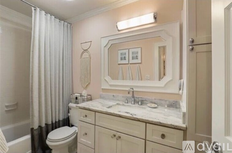 A bathroom with a toilet, sink, and mirror.