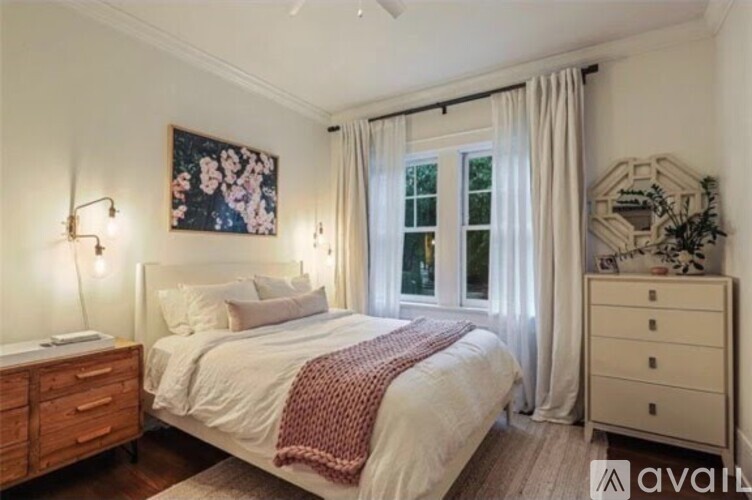 A bedroom with a large bed, a nightstand, and a dresser.
