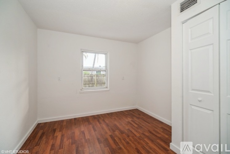 A room with a wooden floor and a window.