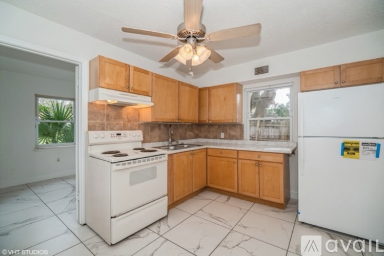 A kitchen with a white stove and a white refrigerator.