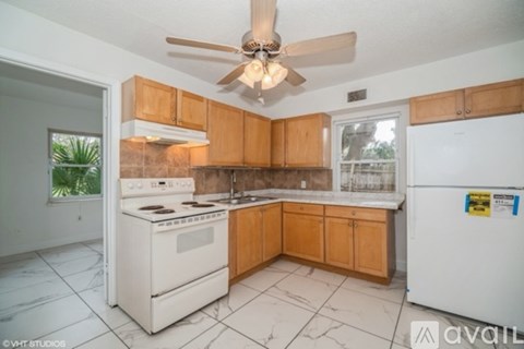 A kitchen with a white stove and a white refrigerator.