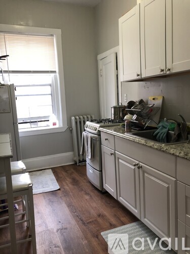 A kitchen with white cabinets and a window.